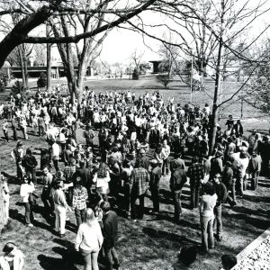 A black and white arial photo of a large group of students gathered on the south campus lawn in 1970 for a peace march.